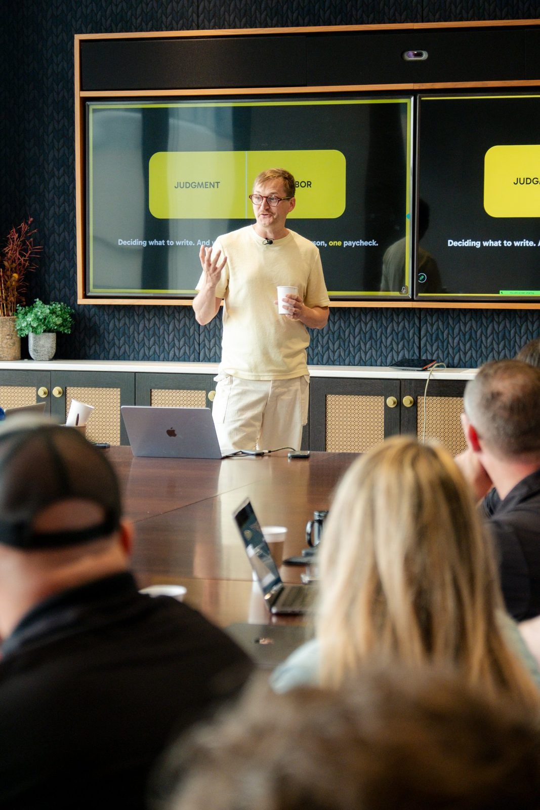 A speaker explains judgment versus labor to a room of business owners