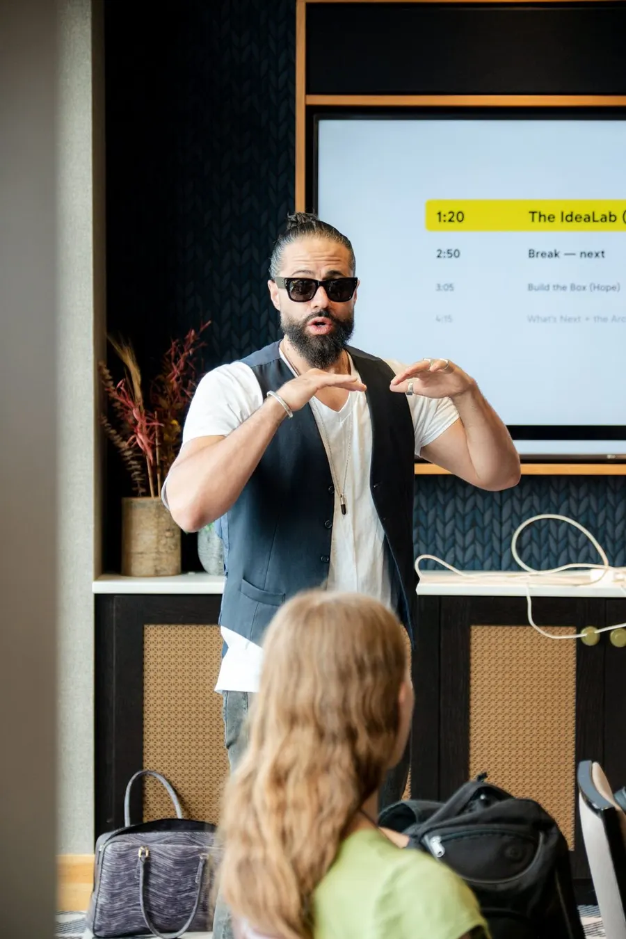 A speaker in sunglasses leads a session at Business Agents of Change